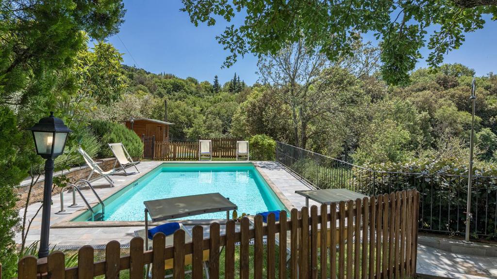 - une piscine dans une cour avec une clôture en bois dans l'établissement I Mandorli 8, Emma Villas, à Cortone