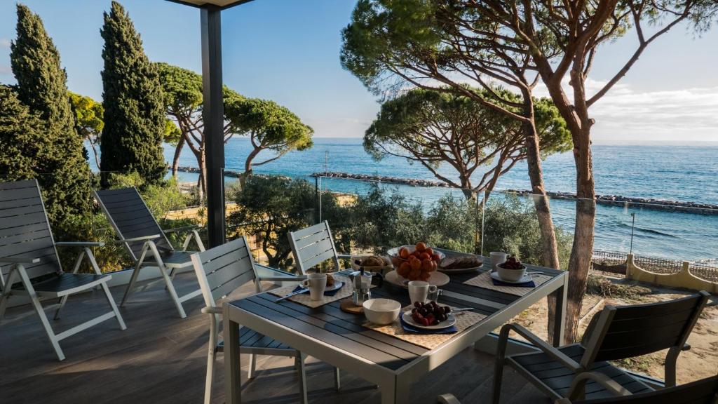 a table and chairs on a patio overlooking the ocean at Appartamenti BluMare in Diano Marina