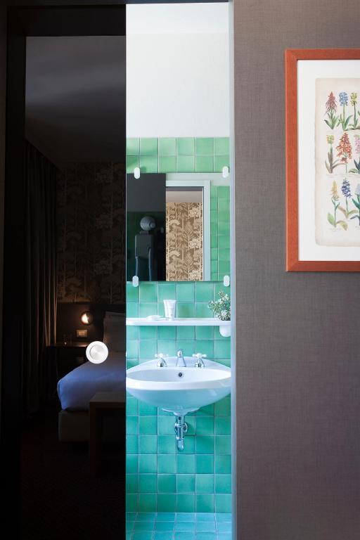 a bathroom with a sink and a room with a bed at Hotel Tremoggia in Chiesa in Valmalenco