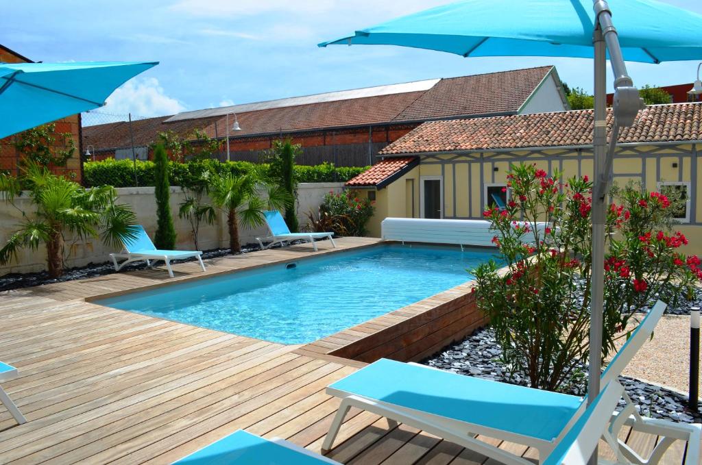 une piscine avec des chaises et un parasol dans l'établissement Résidence L'art Doise, à Rochefort