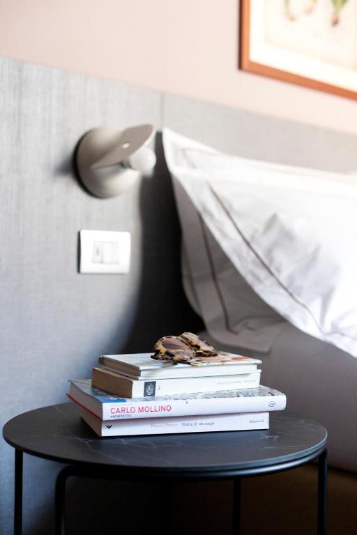 a stack of books on a table with a lamp at Hotel Tremoggia in Chiesa in Valmalenco