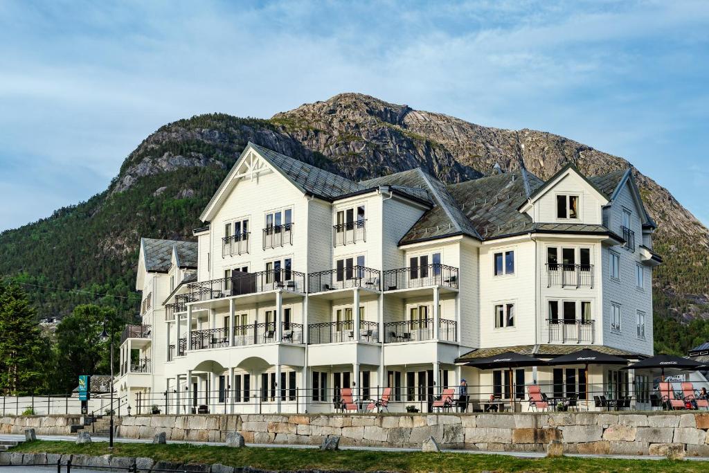 Vøringfoss Hotel في إيدفيورد: مبنى أبيض كبير مع جبل في الخلفية