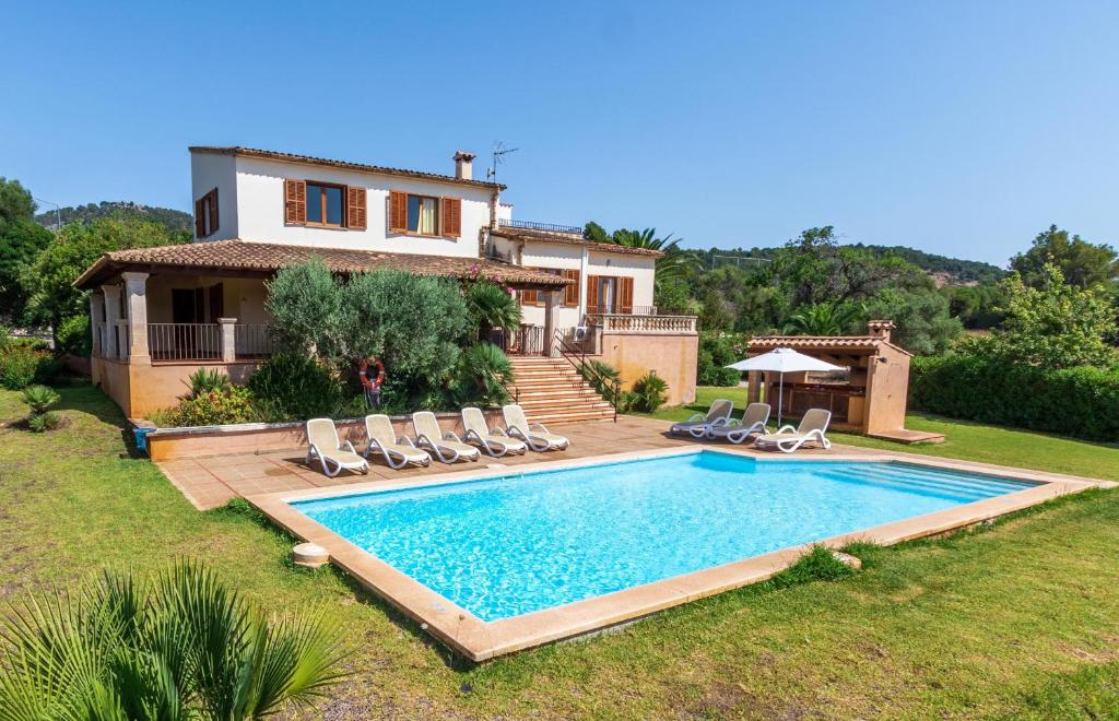 una villa con piscina di fronte a una casa di Villa Hostalet a Pollença