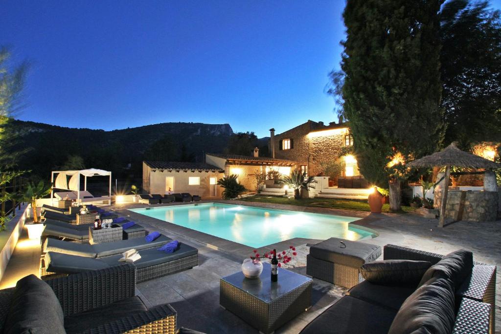 a swimming pool with couches and chairs next to a house at Villa Jaume Ramona in Pollença