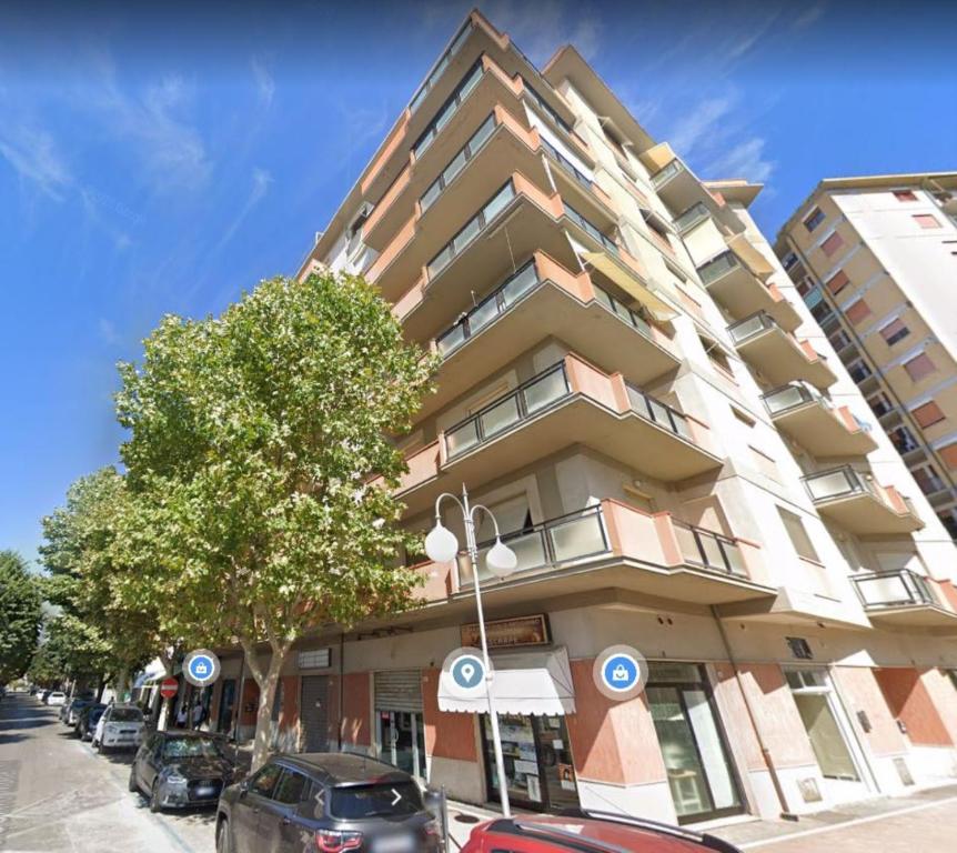 a tall building with cars parked in front of it at Pineta di ponente in Follonica