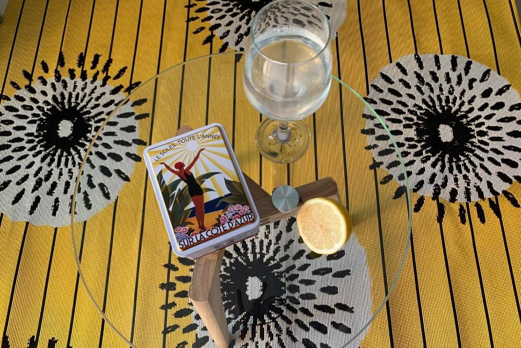 une table avec un verre de vin et quelques fleurs en papier dans l'établissement Bel appartement à 100 mètres de la plage, à Nice