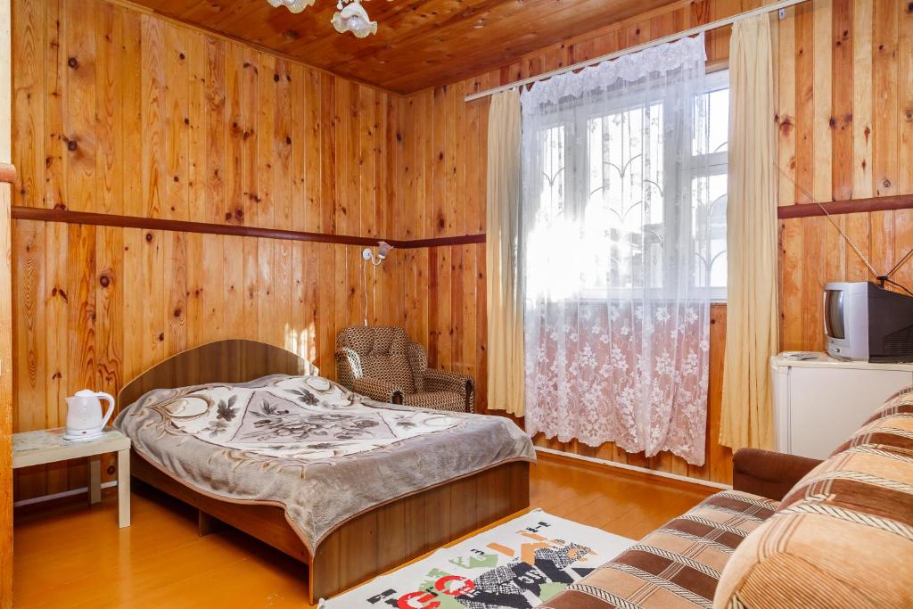 a bedroom with a bed and a window at Гостевой дом Никус in Gagra