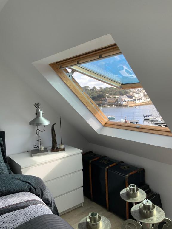 a bedroom with a window with a view of the water at Au Charme d'Audierne -Appartement Vue sur le Port in Audierne