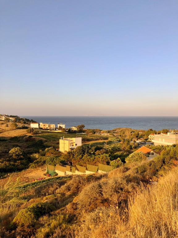 a town on a hill with the ocean in the background at Pelagia Bay Hotel in Agia Pelagia