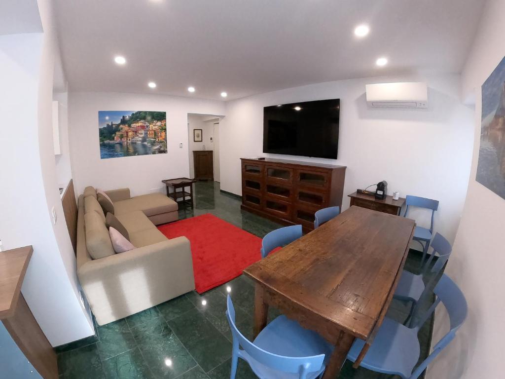 uma sala de estar com uma mesa de madeira e uma televisão em La Casa sul Lago Lecco 2 em Lecco