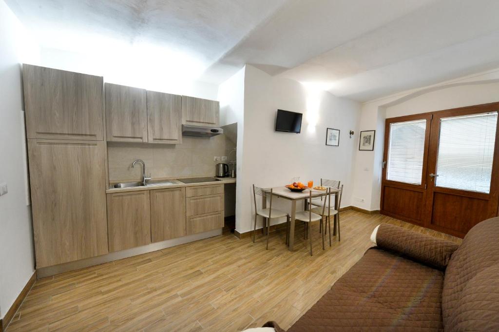 eine Küche und ein Wohnzimmer mit einem Tisch und einem Sofa in der Unterkunft Perugia Apartments in Perugia
