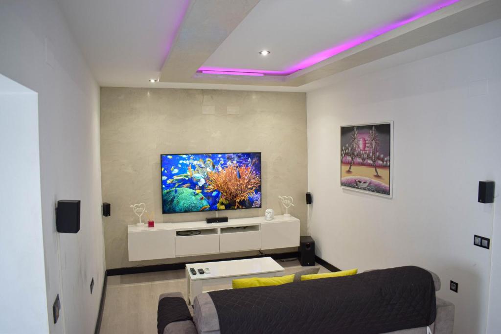 sala de estar con sofá y TV en Apartamento Luxury Home Huelva Zona centro, en Huelva