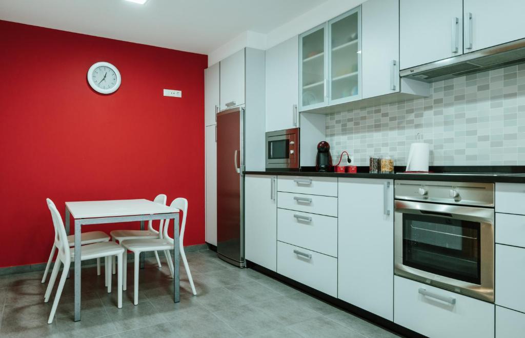 cocina con mesa y pared roja en Apartamento nuevo al lado de la playa en A Guarda, en A Guarda