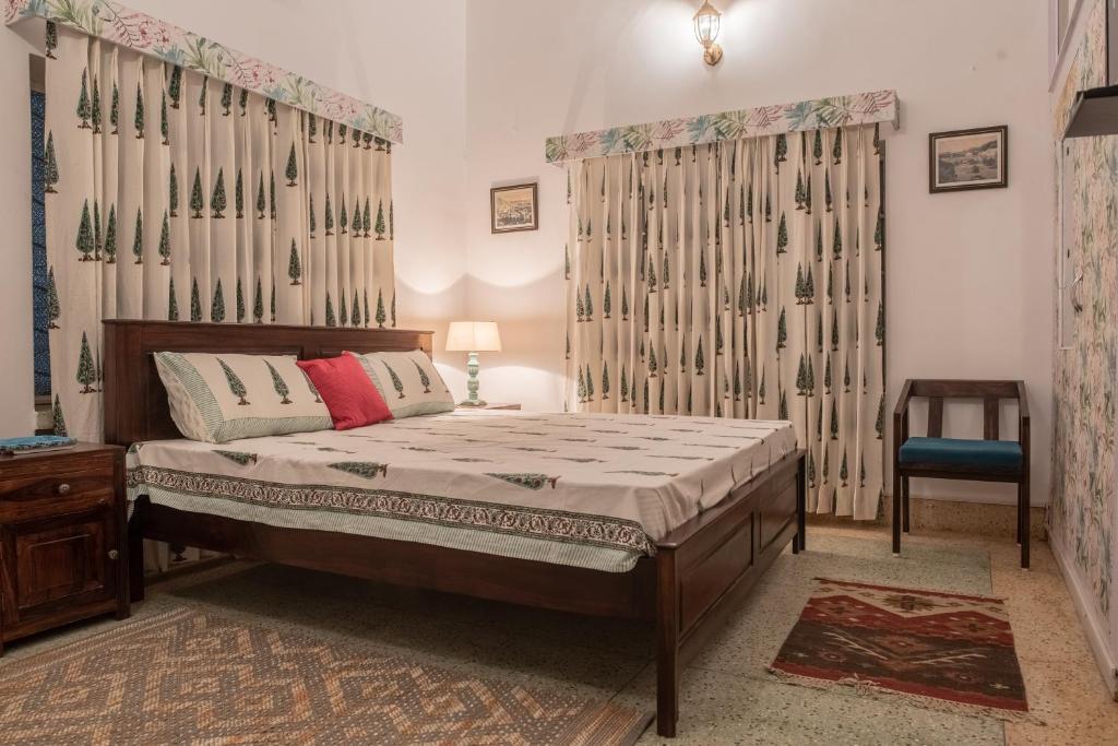 um quarto com uma cama, uma mesa e uma cadeira em Jaipur 1727 Homestay em Jaipur