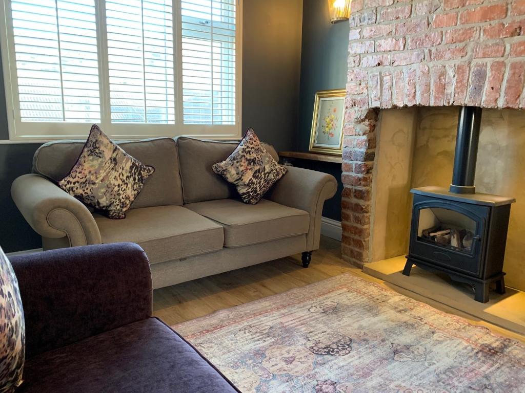 a living room with a couch and a fireplace at Griff Cottage, Skinningrove in Skinningrove