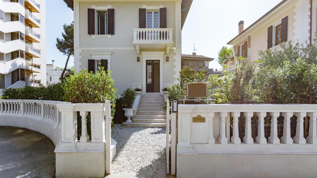 una casa bianca con una recinzione bianca e scale di VILLA CORONA 8, Emma Villas a Cattolica