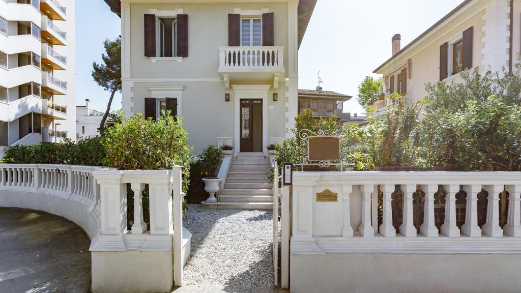 a white house with a white fence and stairs at VILLA CORONA 8, Emma Villas in Cattolica