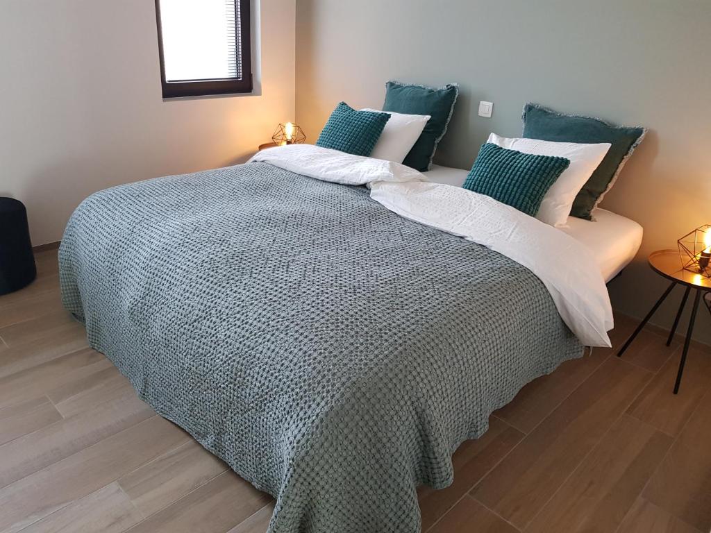 - une chambre avec un grand lit et des oreillers bleus dans l'établissement Vakantiewoning Ijzerfront 14-18, à Dixmude