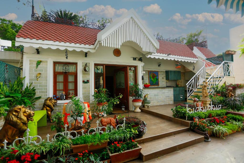 a small white house with a porch with flowers at Terrace Gardens in Bangalore