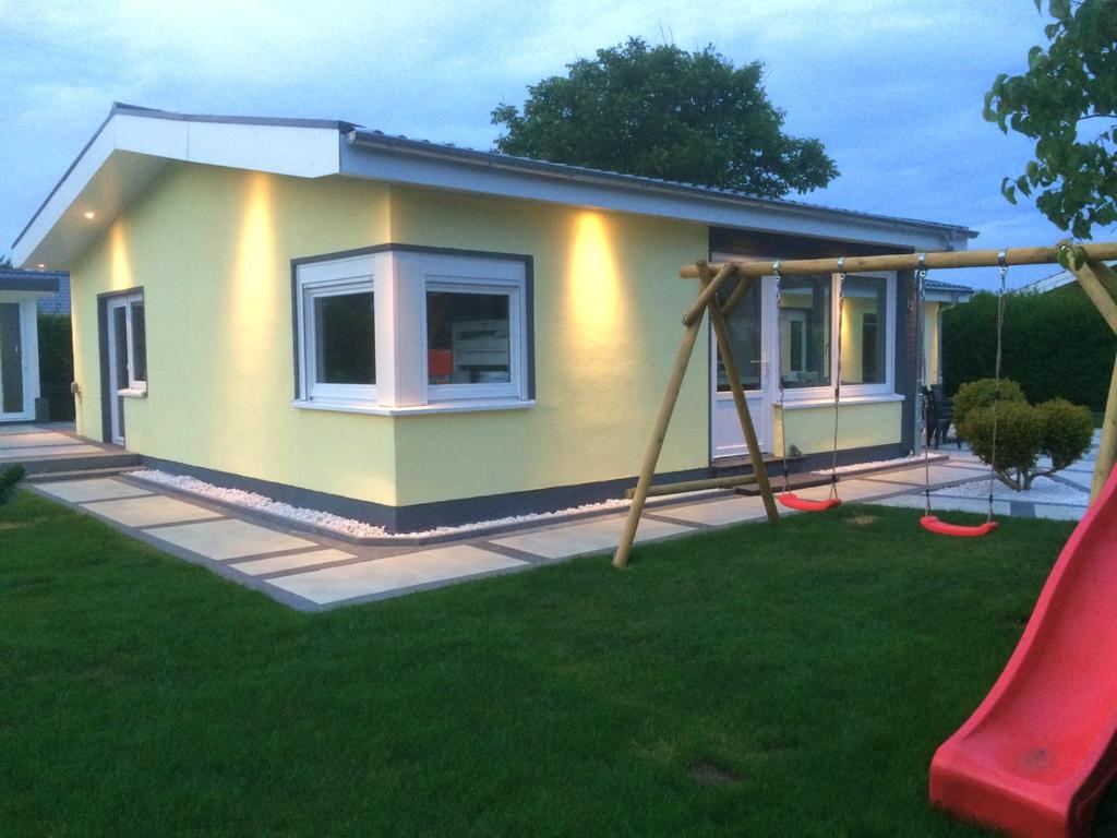 a small house with a swing in a yard at Möwennest in Schönhagen