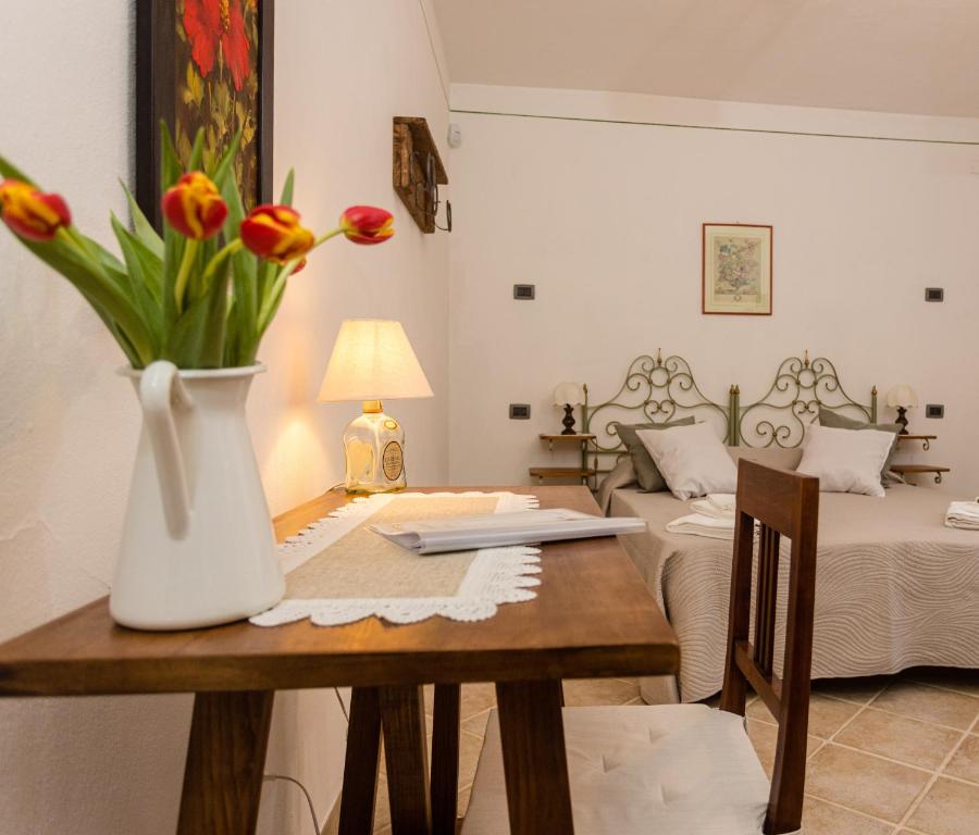 una stanza con un tavolo e un vaso di fiori di Locazione Turistica Casa Vento della Toscana a Foiano della Chiana