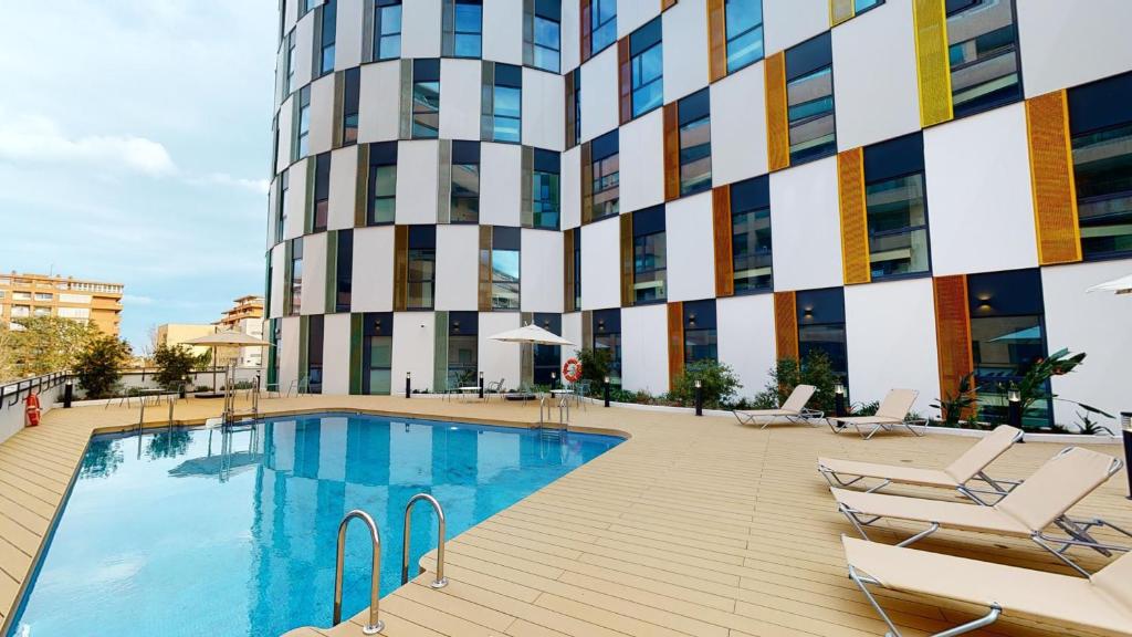 une piscine en face d'un bâtiment dans l'établissement Resa Patacona, à Valence