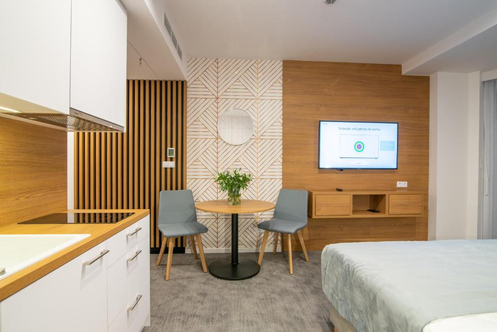 Schlafzimmer mit einem Bett, einem Tisch und einem TV in der Unterkunft Seaside Apartaments Deluxe 627 in Kołobrzeg