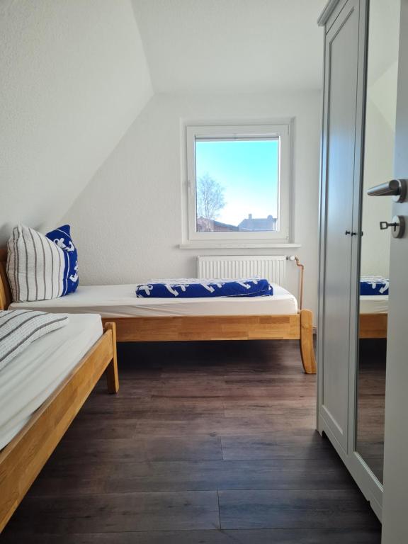 una camera da letto con due letti e una finestra di Wohnung "Burgtiefe" in Bannesdorf auf Fehmarn a Fehmarn