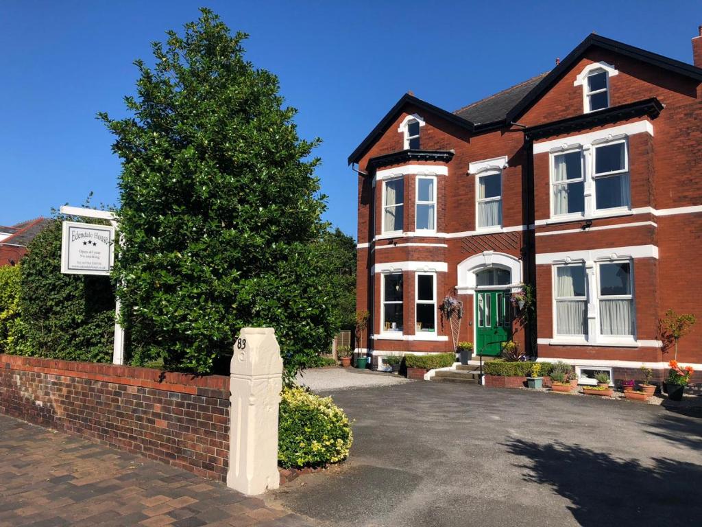 a brick house with a tree in front of it at Edendale House in Southport