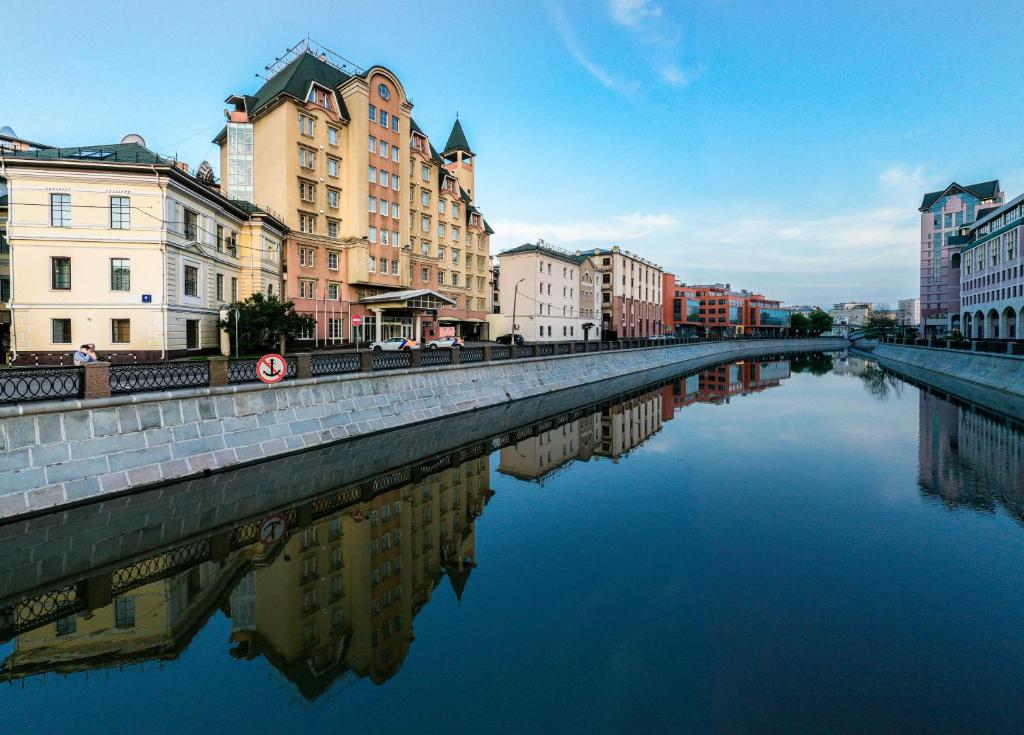 a river in the middle of a city with buildings at BUSINESS-HOTEL ROSSO RIVA in Moscow
