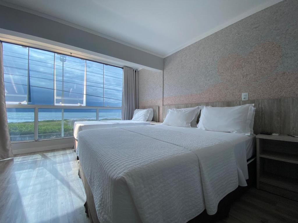 En eller flere senger på et rom på Navega Beach Palace Hotel