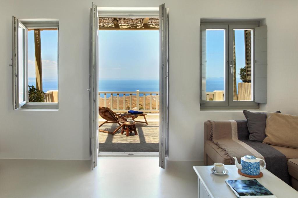 a living room with a door open to a patio at Kea Village Suites & Villas in Ioulida