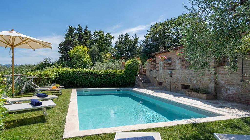 - une piscine dans une cour avec un parasol dans l'établissement L'Oliveta 6, Emma Villas, à Gambassi Terme