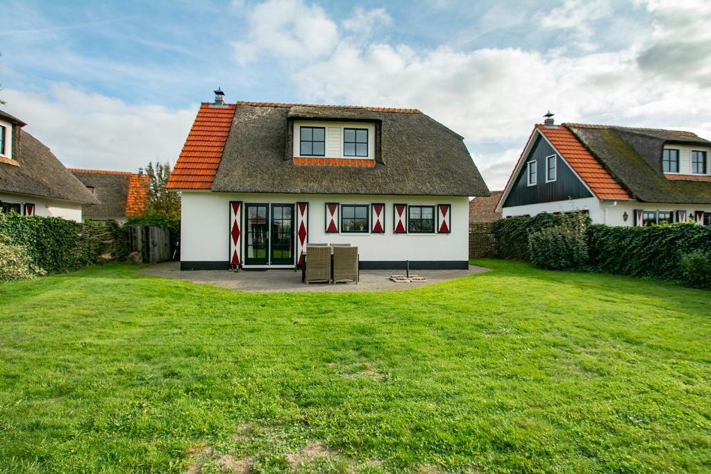 een huis met een gazon ervoor bij Buitenplaats Villa 116 - Callantsoog in Callantsoog