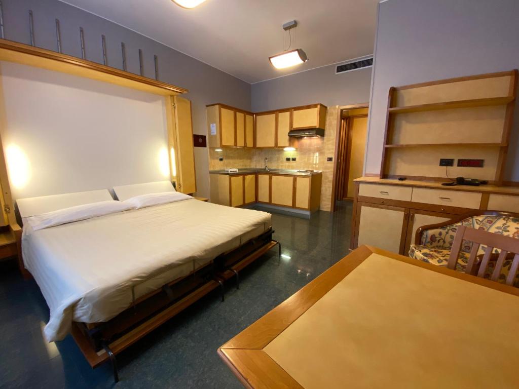 1 dormitorio con 1 cama grande y cocina en Le Petit Hotel, en Turín