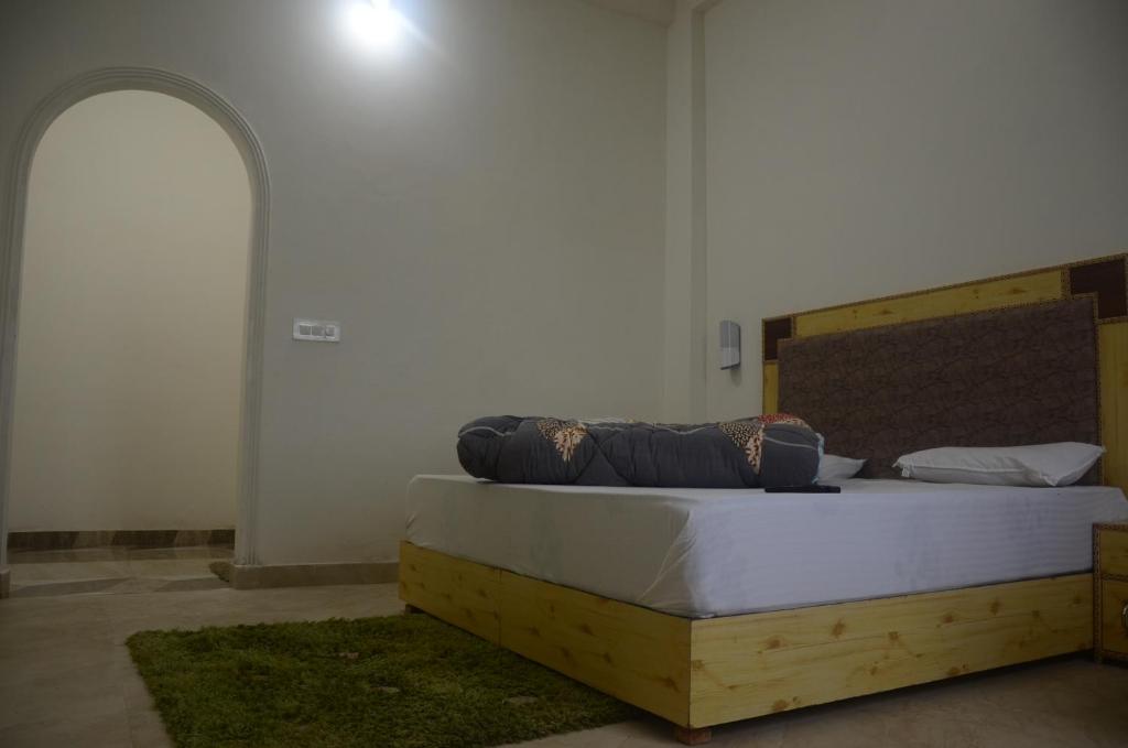 een slaapkamer met een groot bed met een houten frame bij Himalayan Canvas in Khajjiar 