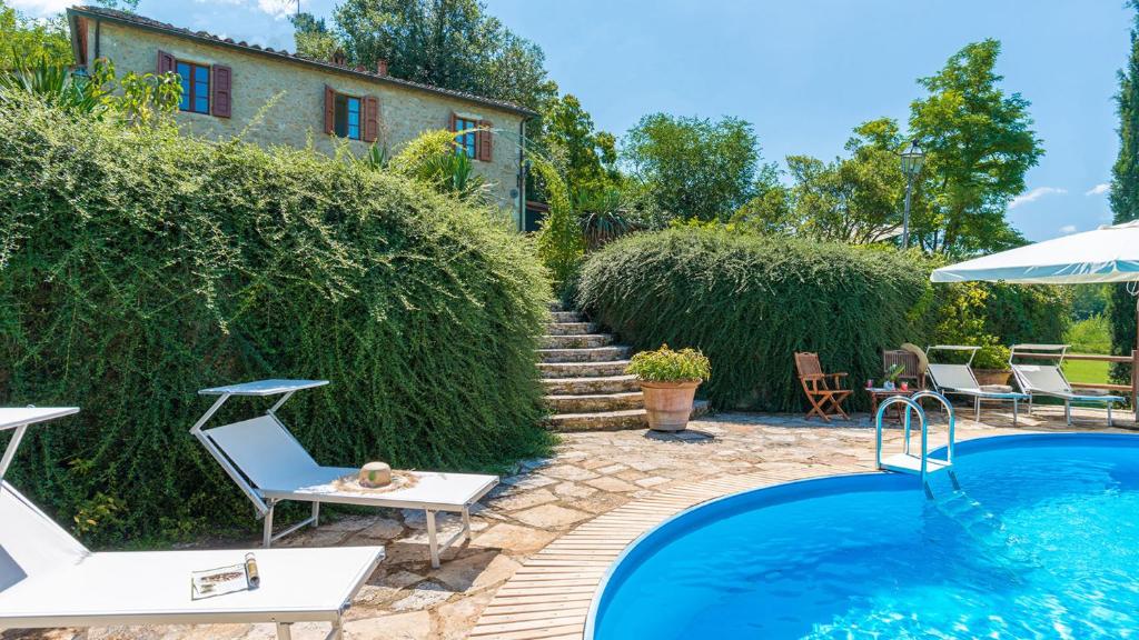 a backyard with a swimming pool and a house at LA CASA DELL'ARTISTA 6, Emma Villas in Asciano