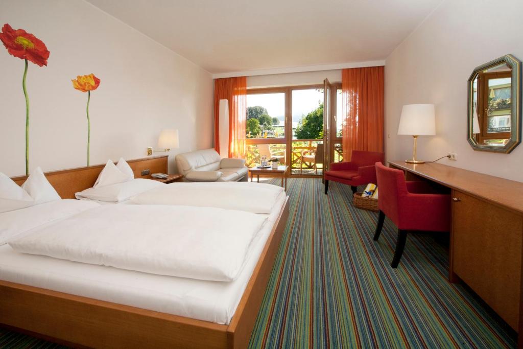 A bed or beds in a room at Seehotel Engstler