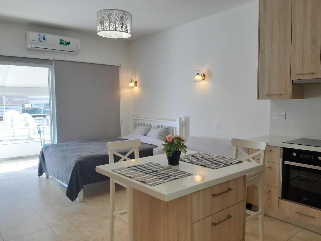 a bedroom with a bed and a kitchen with a table at Sun sea B102 apartment by the beach in Limassol