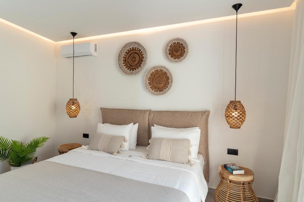 a bedroom with a white bed and pendant lights at Giorgio Deluxe Studio in Kattavía