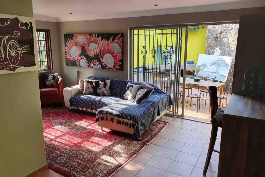 a living room with a couch and a table at GILLFORD GALLERY ACCOMMODATION in Benoni