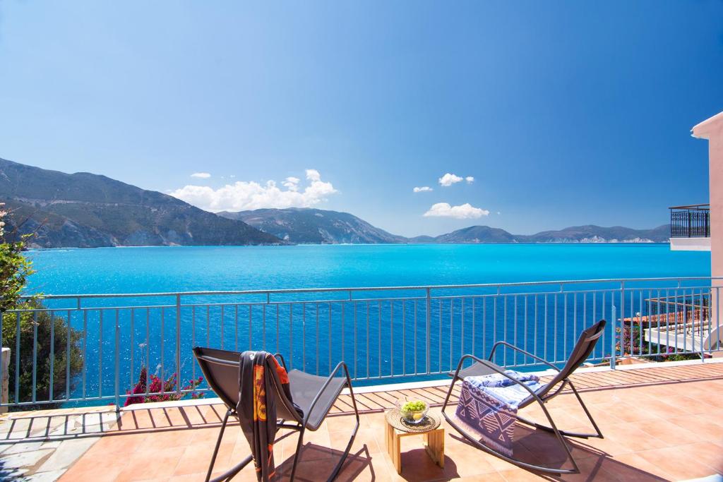 een balkon met 2 stoelen en uitzicht op het water bij Villa M in Asos