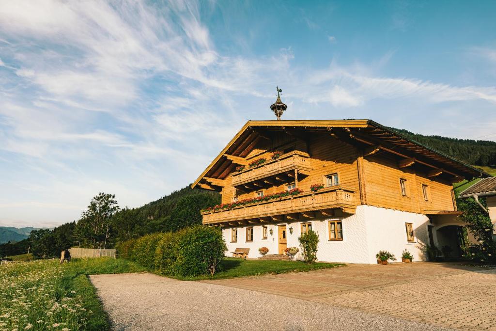 a large wooden building with a cross on the roof at Wimmhof in Sankt Martin am Tennengebirge