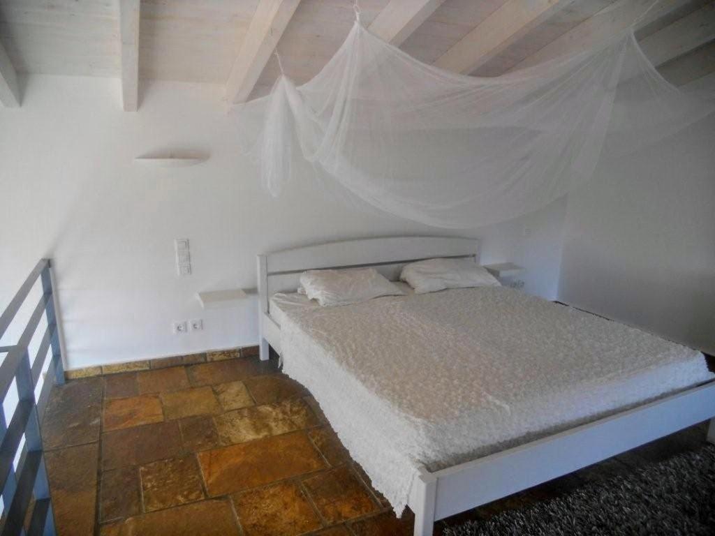 A bed or beds in a room at Natur-Steinhaus mit Meerblick: hell, ruhig, exklusiv, strandnah