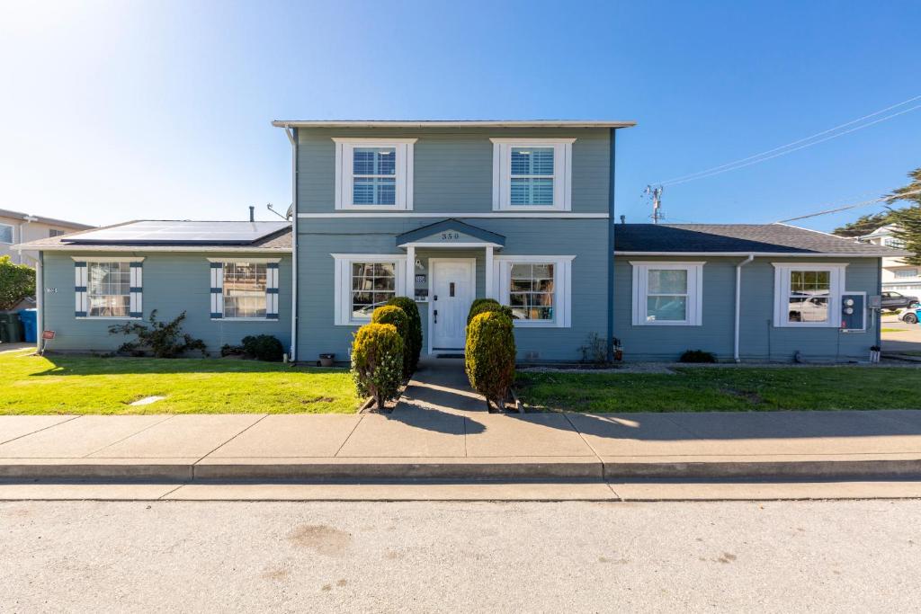 a blue house with two bushes in front of it at @ Marbella Lane - Buckingham Place Laundry + P in Pacifica