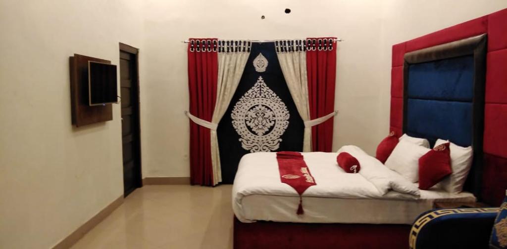 a bedroom with a bed and a red curtain at Hotel The Holiday in Lahore