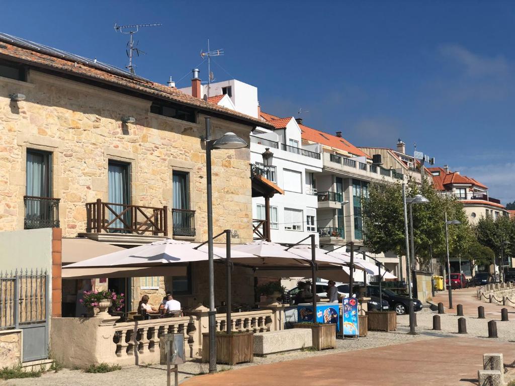 a restaurant with umbrellas in front of a building at A Esmorga-Posada del Mar in Vilagarcia de Arousa