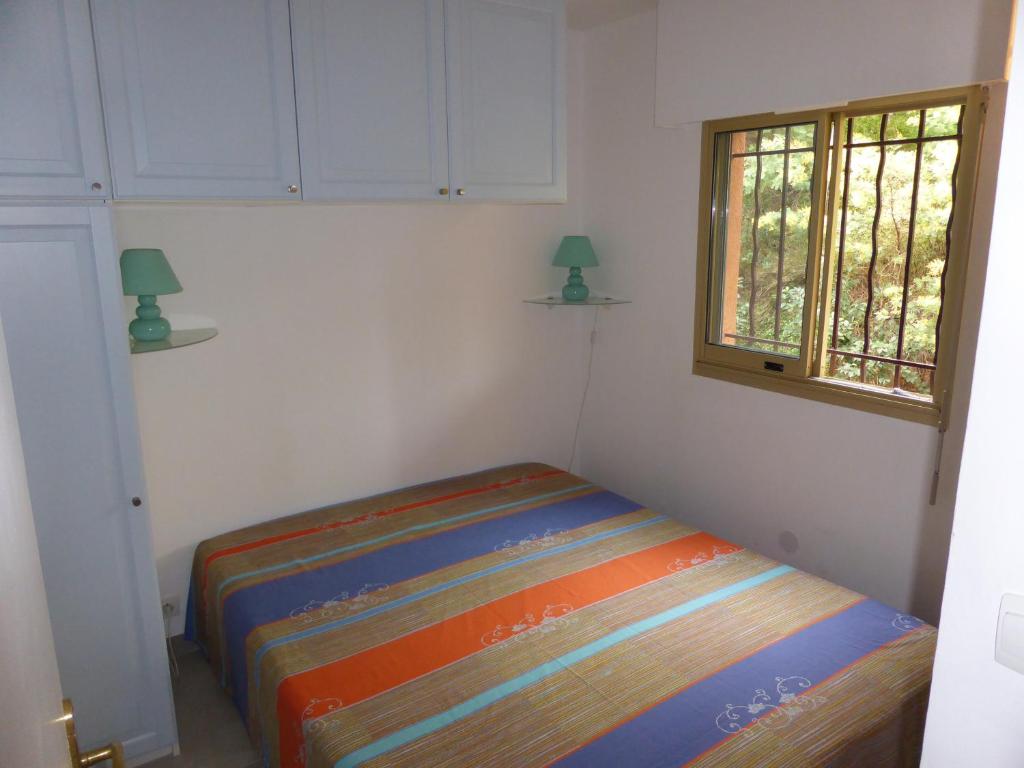 a bed in a room with a window at Plage de Miramar in Théoule-sur-Mer