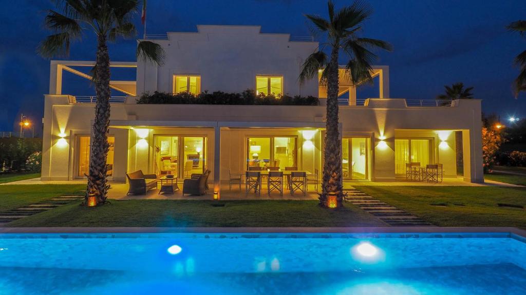 willa z basenem nocą w obiekcie PORTOVERDE BEACH VILLA 12, Emma Villas w mieście Misano Adriatico
