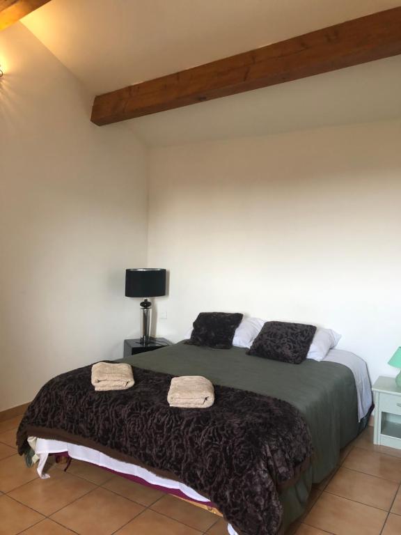 een slaapkamer met een bed met twee handdoeken erop bij Gite Les Oliviers in Sablet